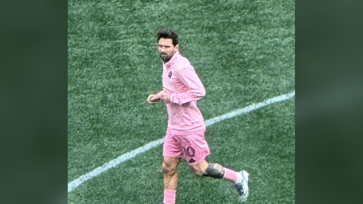 Lionel Messi in a pink Inter Miami kit jogs across the field during warmups before the 2025 Leagues Cup final