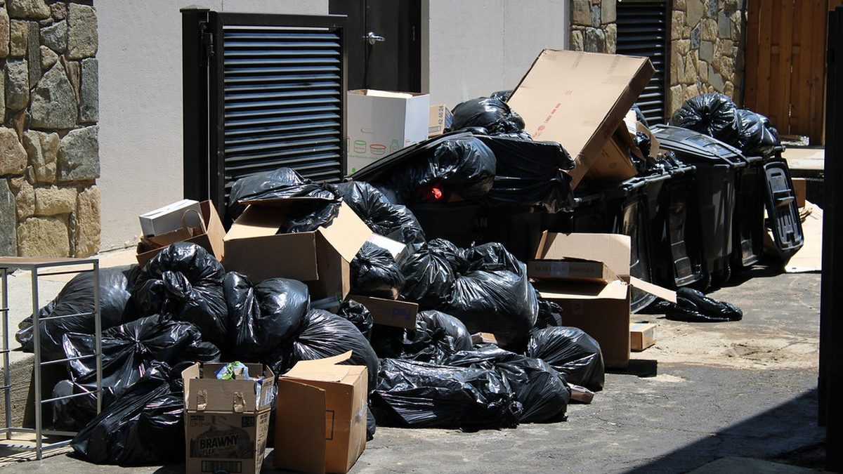 Black trash bags and boxes piled up outside a building