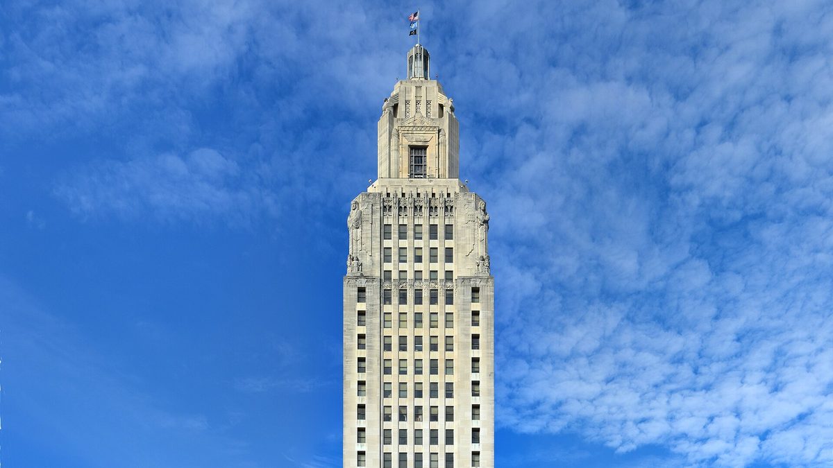 The art deco crown of the Louisiana State Capitol tower in Baton Rouge against a blue sky