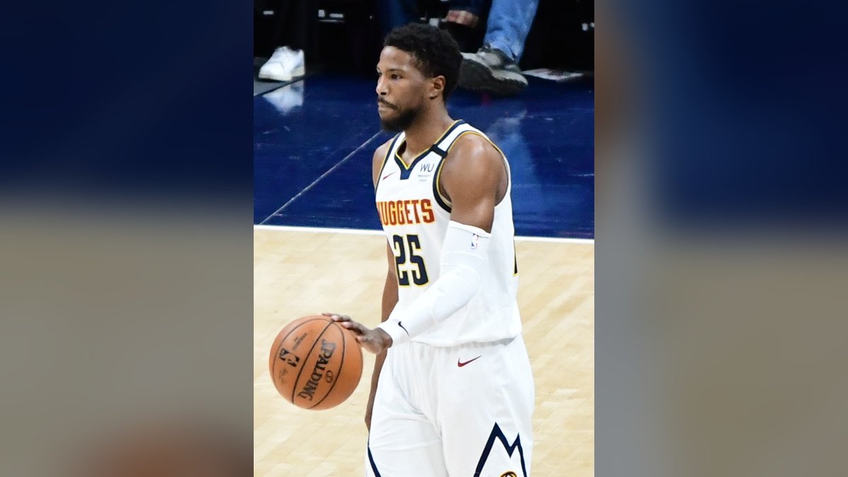 Malik Beasley dribbling up the court in a white Denver Nuggets No. 25 jersey