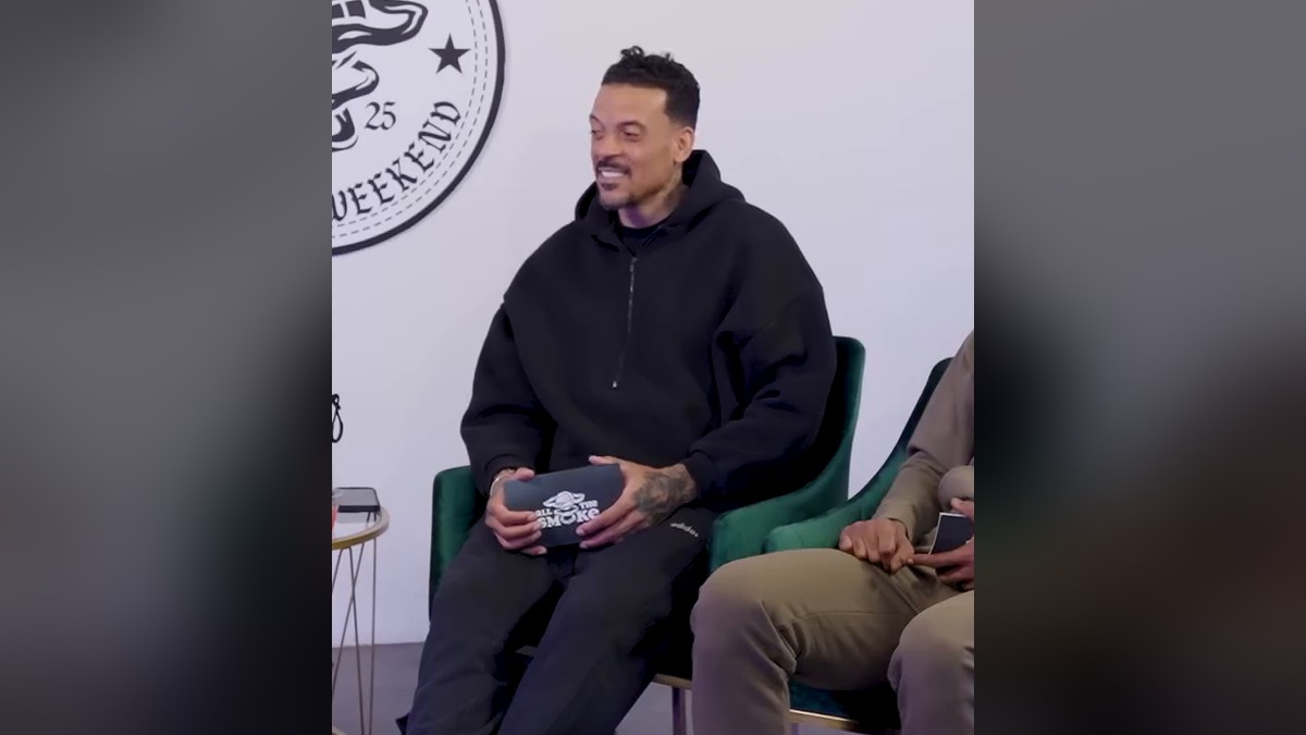 Matt Barnes smiling in a black hoodie on a podcast set