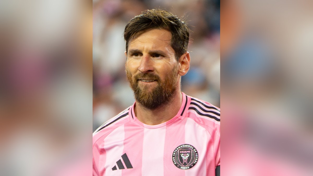 Lionel Messi smiling in a pink Inter Miami jersey