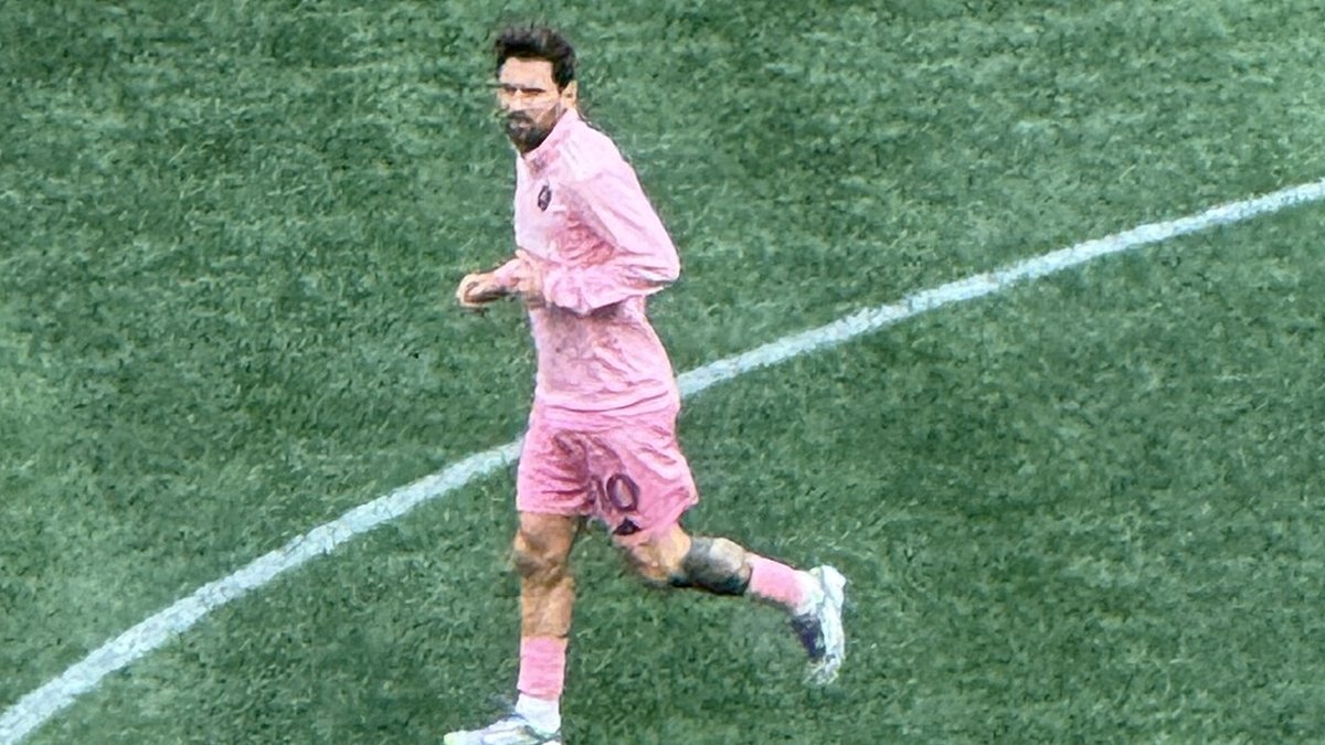 Lionel Messi in a pink Inter Miami training kit jogging on the field during warmups before the 2025 Leagues Cup final