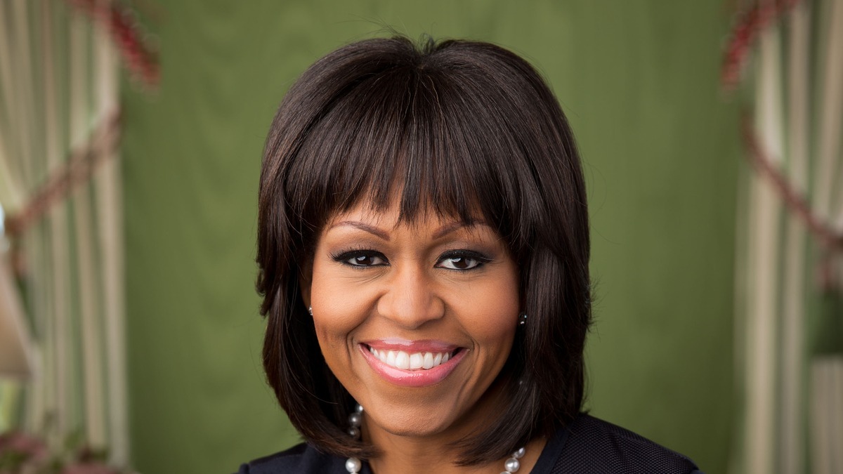 Official White House portrait of Michelle Obama smiling in a formal setting with a soft green background