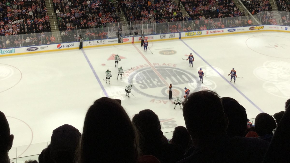 Fans in silhouette watching an Edmonton Oilers home game from the upper deck at Rogers Place