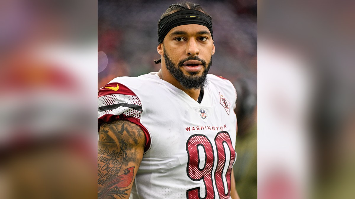 Montez Sweat in a white Washington No. 90 jersey and a black headband before a game