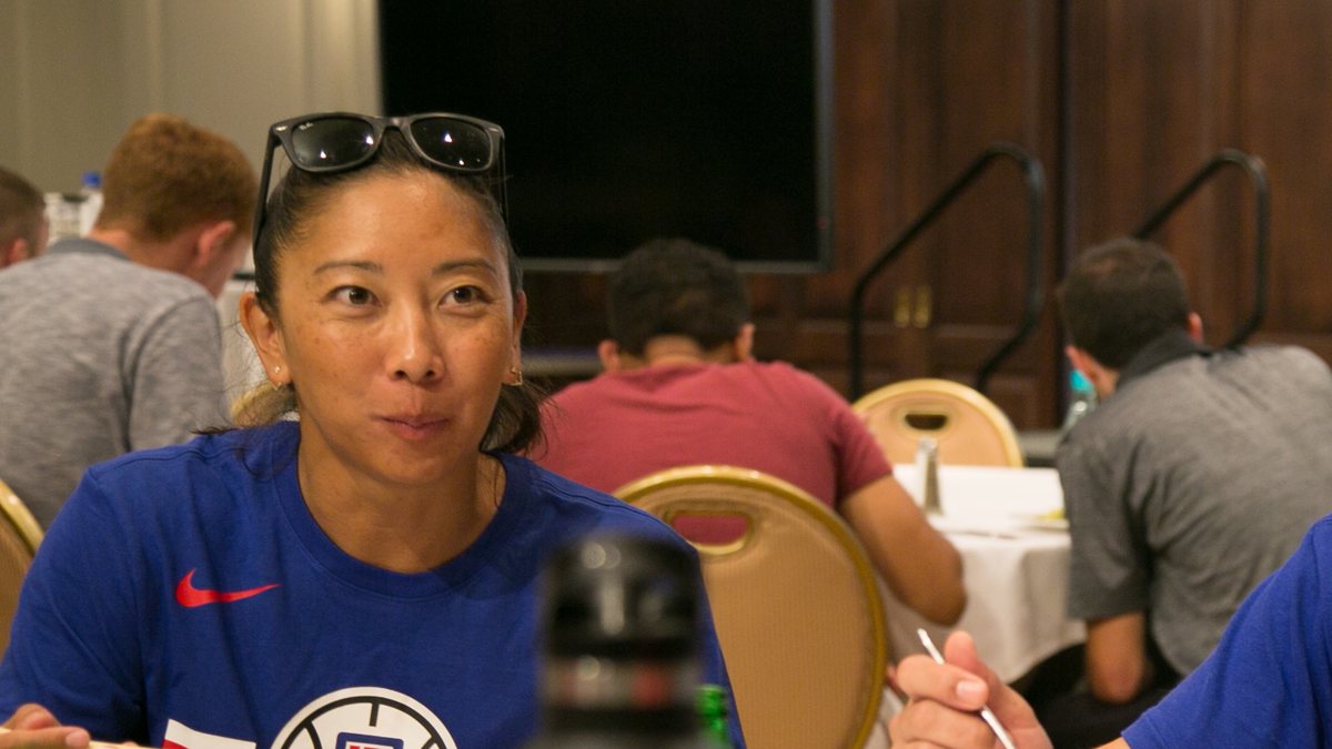 Natalie Nakase in a blue Los Angeles Clippers shirt with sunglasses on her head during a team meal with soldiers in Hawaii