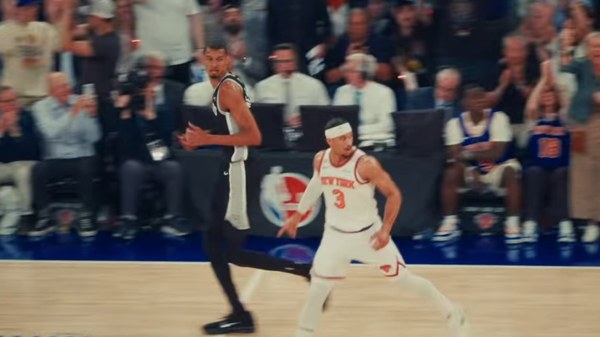 Victor Wembanyama in a black Spurs jersey runs upcourt behind Josh Hart of the Knicks during the 2026 NBA Finals