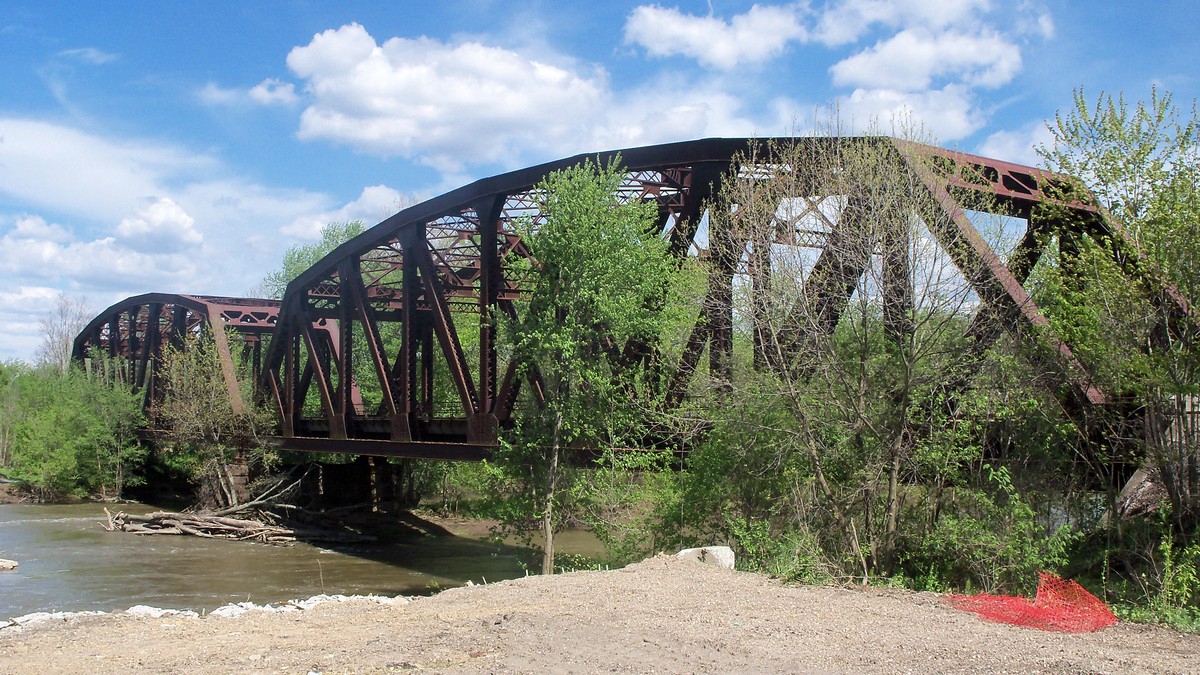 A rust-colored railroad bridge over the Tuscarawas River in Gnadenhutten, Ohio