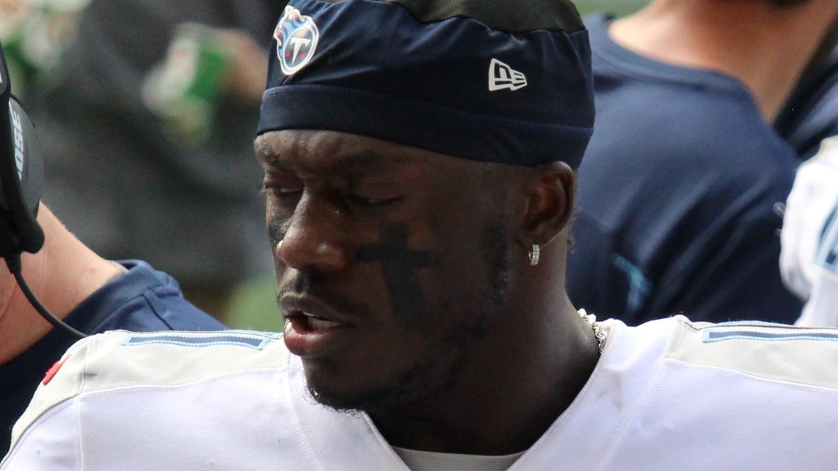 Receiver A.J. Brown in a navy Titans headband and white jersey looks down during a 2021 game