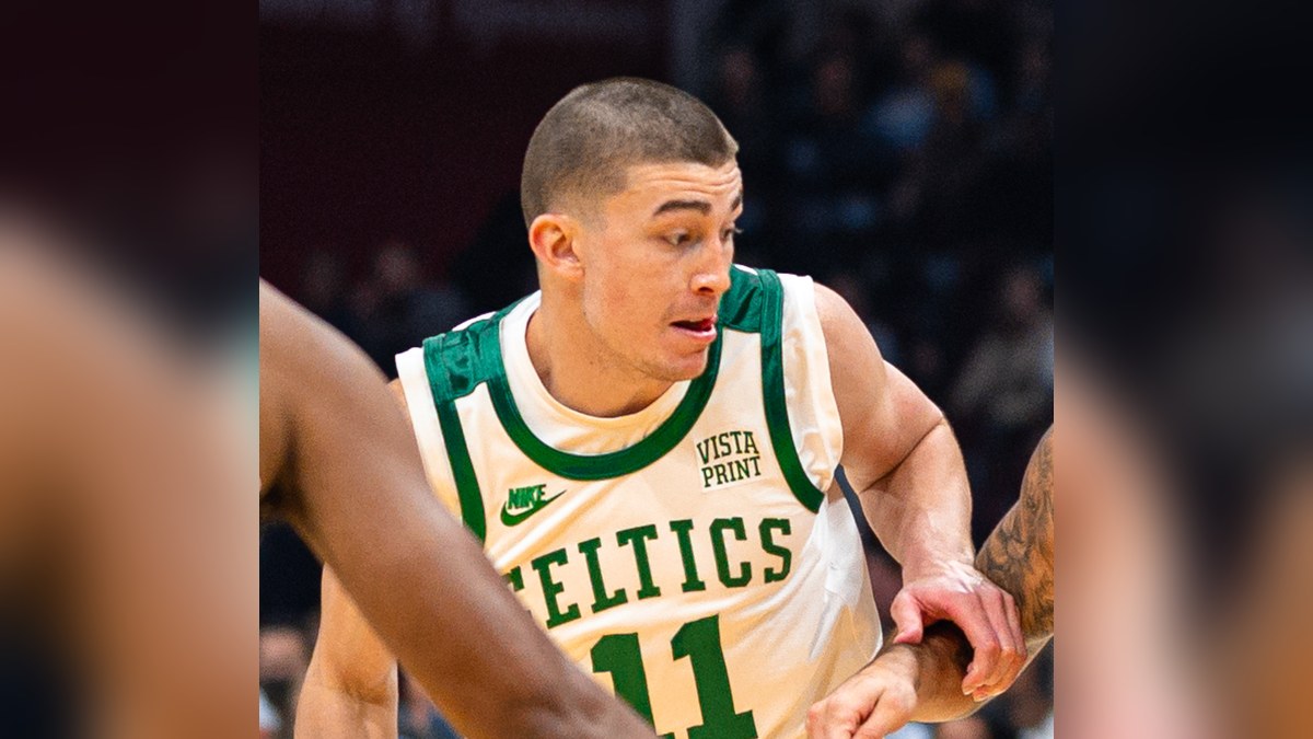 Payton Pritchard in a white Celtics No. 11 jersey drives with the ball during a game