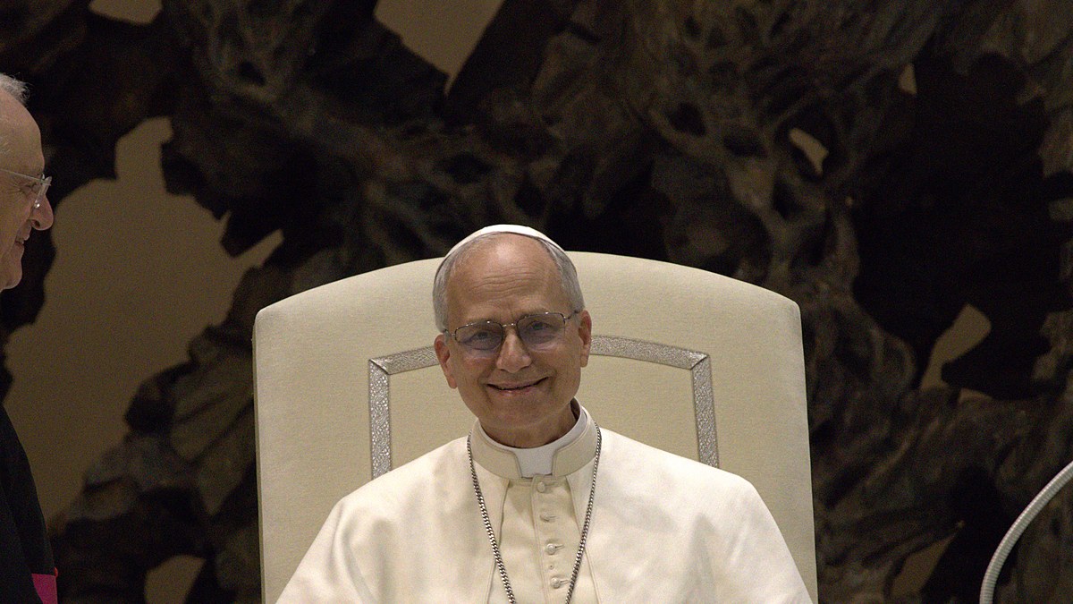 Pope Leo XIV smiling while seated in a white chair
