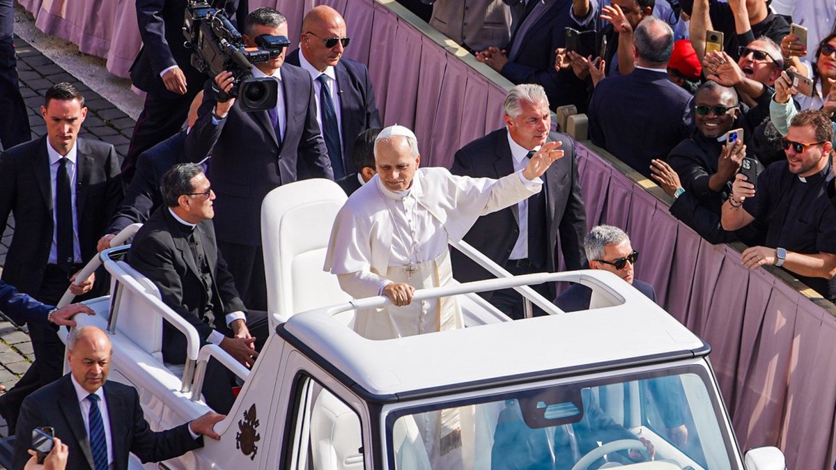 Pope Leo XIV waving to crowds from the popemobile in St. Peter's Square