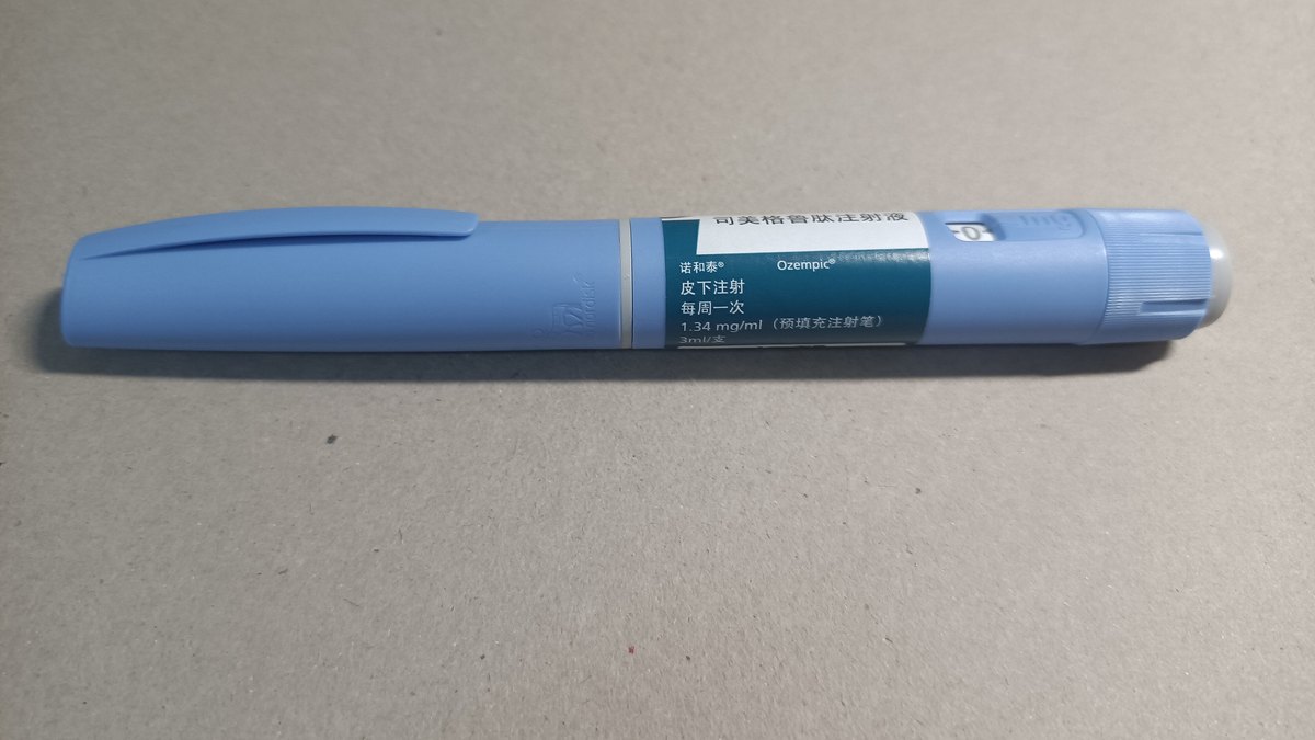 A blue Ozempic semaglutide injection pen on a gray surface, a stand-in photo