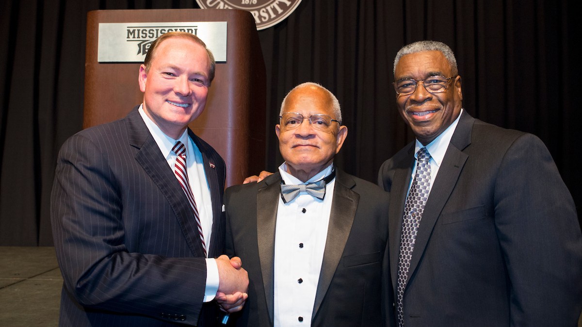 Dr. Richard E. Holmes in a tuxedo and bow tie stands between Mississippi State President Mark Keenum and Dr. Dolphus Weary