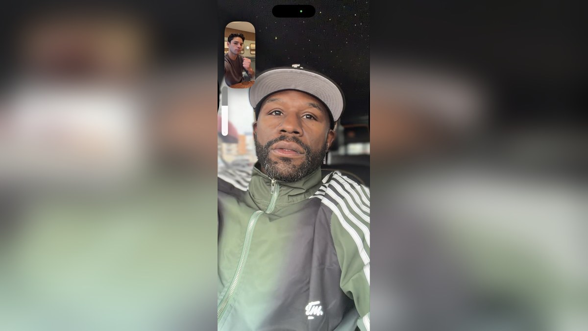 Floyd Mayweather in a gray cap on a FaceTime call with Ryan Garcia shown in the corner window