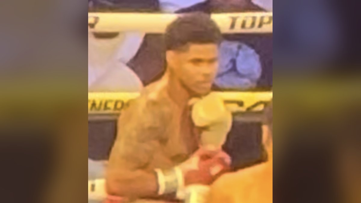 Shakur Stevenson in the ring with his gloves up during a fight as the ropes and crowd sit behind him