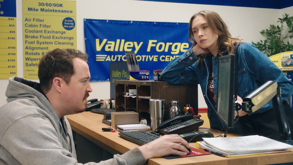 Shane Gillis at a shop counter computer in a still from the Netflix series Tires