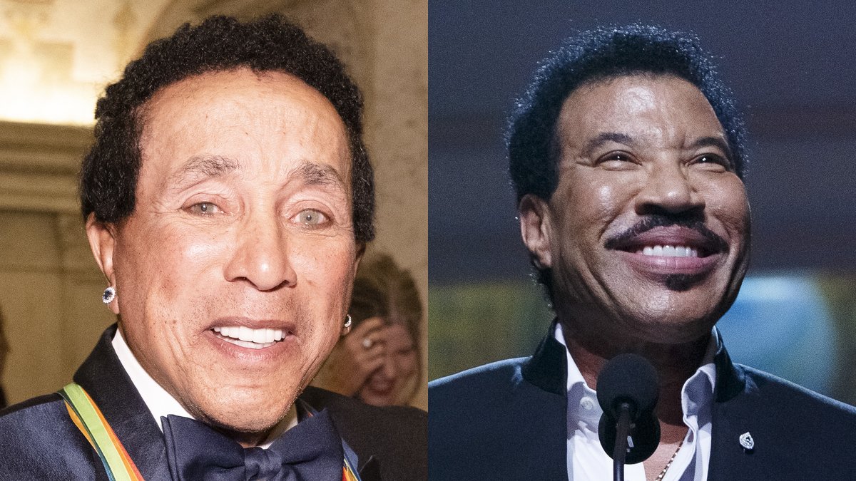 Smokey Robinson and Lionel Richie side by side, both smiling in dark suits at formal music honors