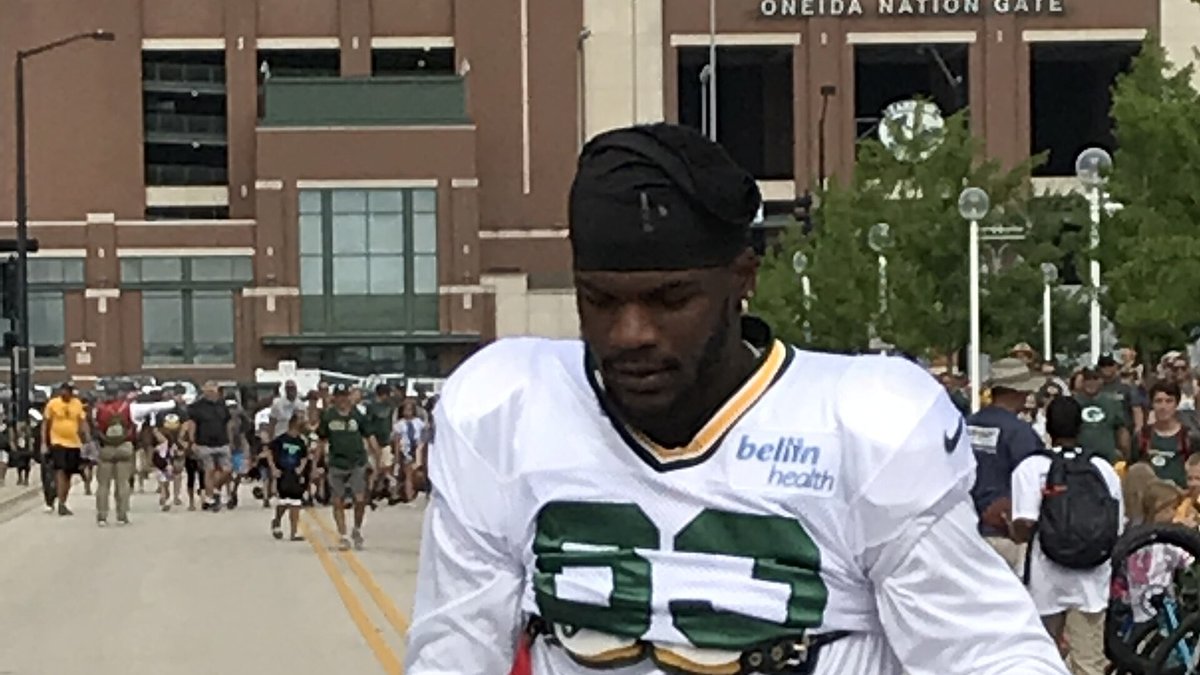 Receiver Marquez Valdes-Scantling walks to practice in a white No. 83 Green Bay Packers jersey at training camp outside Lambeau Field
