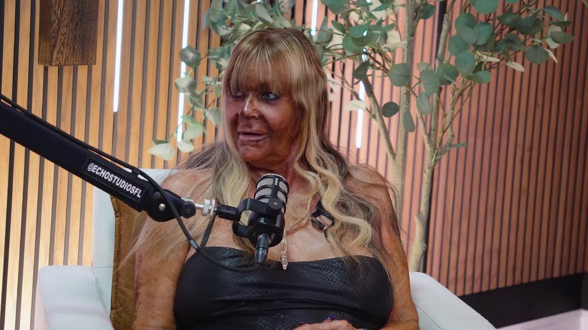 Patricia Krentcil with long blond hair in a black top speaking into a podcast microphone
