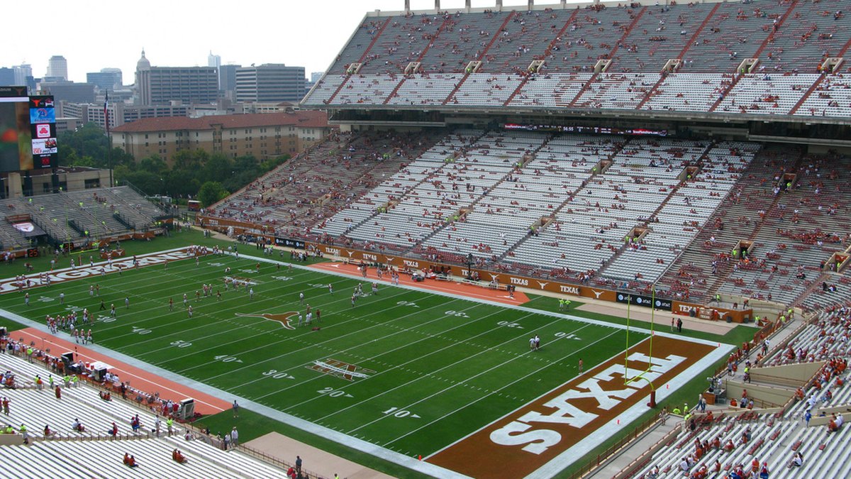 Burnt orange end zone and green field inside Darrell K Royal-Texas Memorial Stadium in Austin with the stands behind