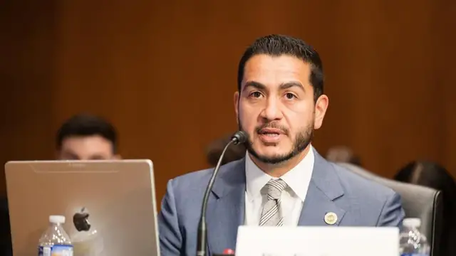 Abdul El-Sayed in a blue suit speaking into a microphone at a Senate hearing