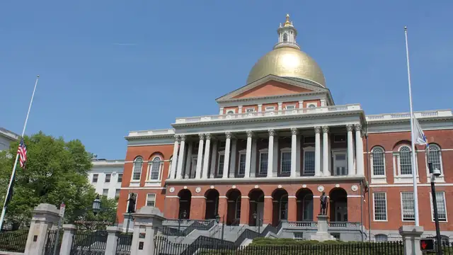 Massachusetts State House with its gold dome and red brick facade under a clear blue sky in Boston