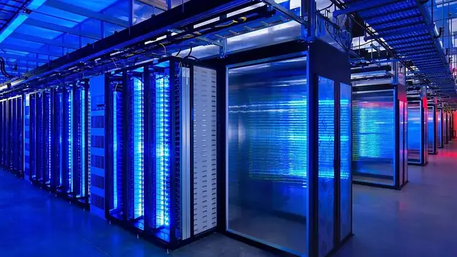 Rows of computer server cabinets glow blue inside a data center