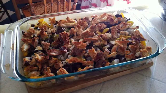 A homemade casserole with a toasted bread topping in a glass baking dish on a kitchen counter