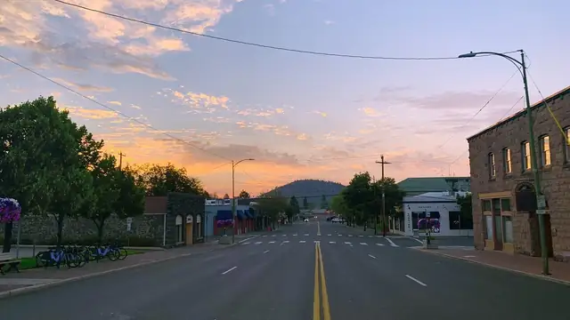 Downtown Bend Oregon streets with Pilot Butte rising in the distance under a clear blue sky