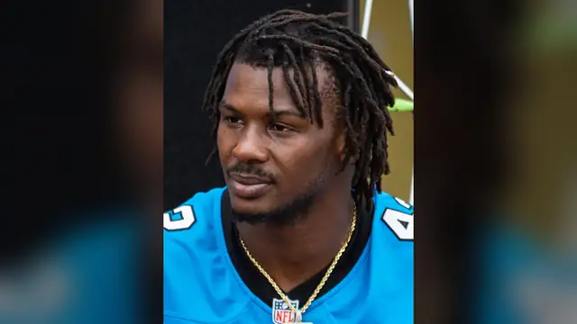 Sam Franklin Jr. in a blue Carolina Panthers jersey and gold chain at a June 2024 community meet and greet