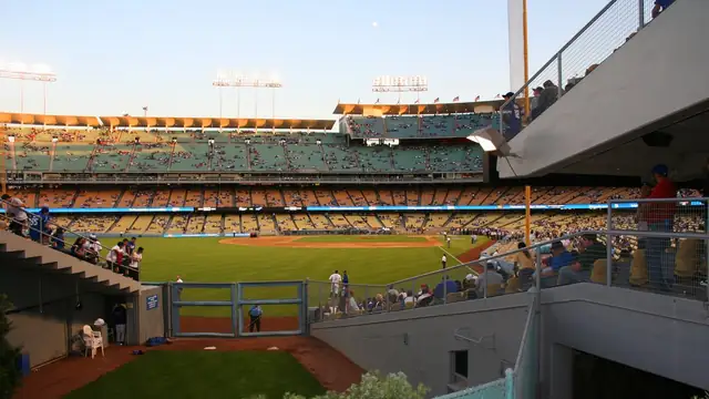Dodger Stadium's green field and tiers of seats seen from beside the home bullpen on a sunny afternoon
