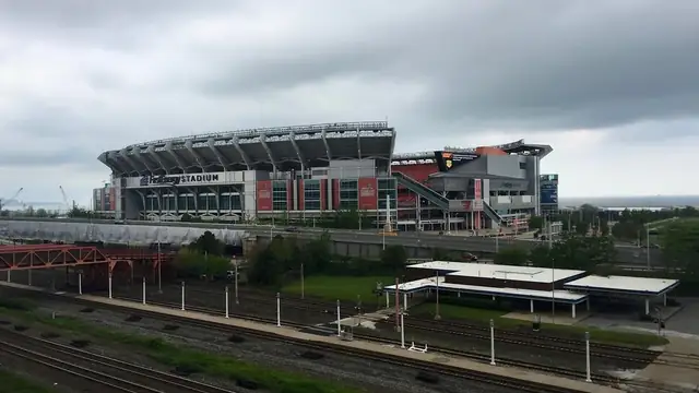 The Browns stadium on the Cleveland lakefront seen across a rail yard on a cloudy day