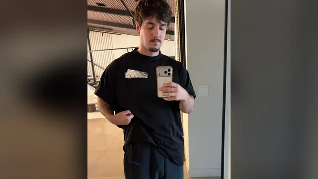Bryce Hall taking a mirror selfie in a black T-shirt