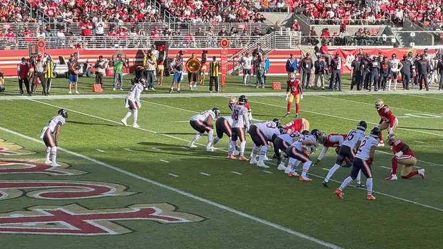 Bears quarterback Caleb Williams in a white No. 18 jersey lines up in the shotgun with the Chicago offense against the 49ers