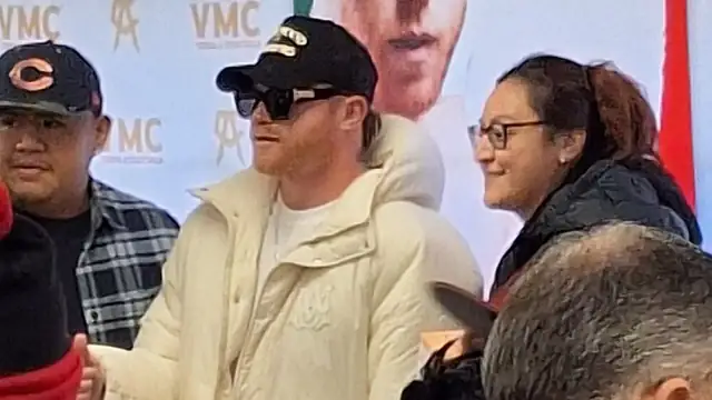 Canelo Alvarez in sunglasses, a black cap and a cream puffer jacket greets fans at a store event in Burbank, Illinois