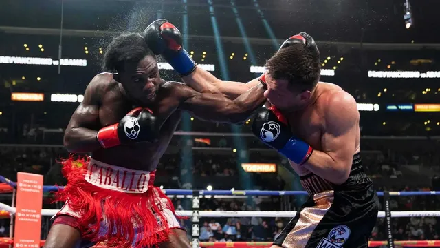 Carlos Adames in red and white trunks lands a right hand on his opponent in the ring