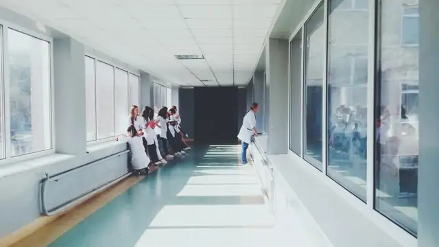 A long hospital corridor with a few people standing near the far end