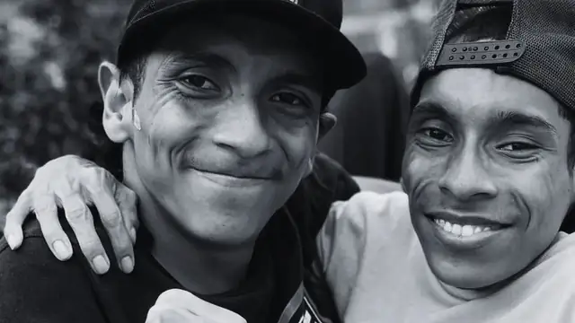 José Luis and José Armando Cevallos smiling in baseball caps in a black-and-white photo