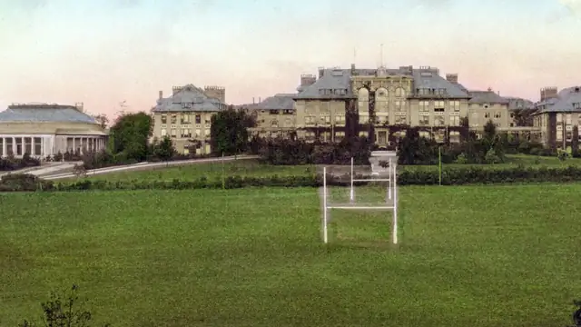 Early 1900s postcard of Bailey Hall and other buildings across a green field at Cornell University
