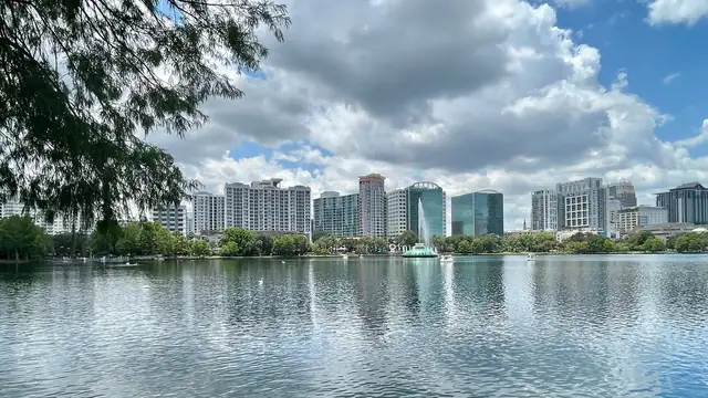 Downtown Orlando high-rises and the Lake Eola fountain under a cloudy sky