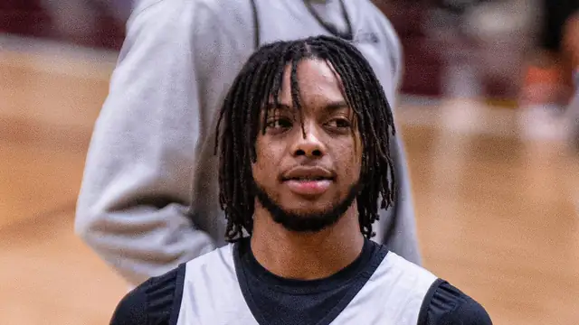 Darius Garland in a gray All-Star practice jersey holding a basketball on the court in 2022