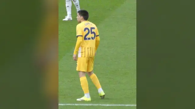 Brighton's Diego Gómez in a yellow No. 25 away jersey stands on the field before a match at Fulham in January 2026