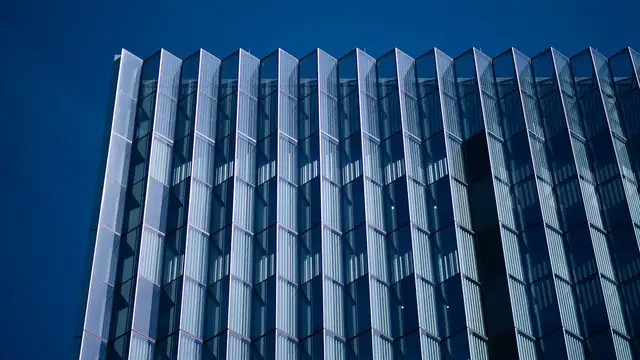 Glass fins of the First Street U.S. Courthouse in downtown Los Angeles rise against a deep blue sky