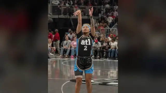 An Atlanta Dream player in a black ATL jersey rises for a shot in front of fans during a 2026 game