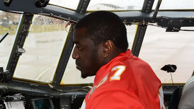 Former Kansas City Chiefs defensive end Allen Bailey in a red Chiefs jersey sits in an aircraft cockpit during a 2015 team visit to Rosecrans Air National Guard Base