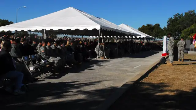Soldiers and families seated under white tents at a Fort Hood memorial ceremony