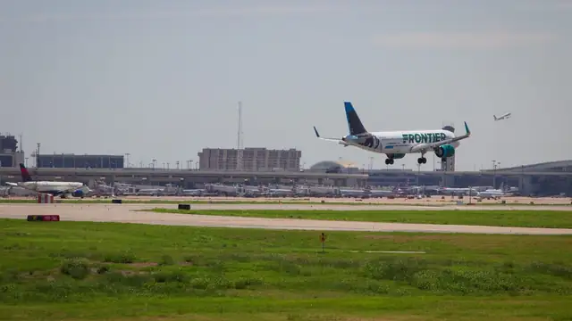 A Frontier Airlines jet landing as a Delta jet takes off