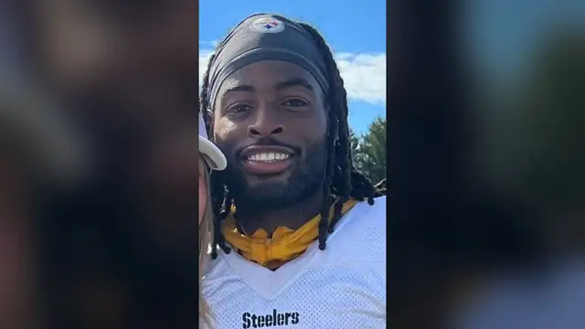 Running back Najee Harris smiles in a white Pittsburgh Steelers jersey with a black headband